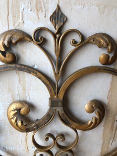 an ornate iron work on the side of a building with peeling paint and chipped plaster