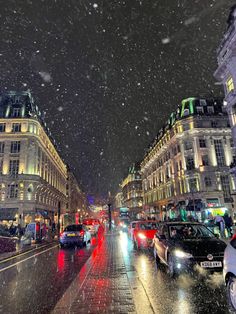 cars are driving down the street on a rainy night in paris, france with snow falling all around