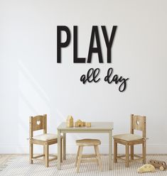 there is a play all day sign on the wall next to two chairs and a table