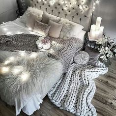 a bedroom with lights and blankets on the bed