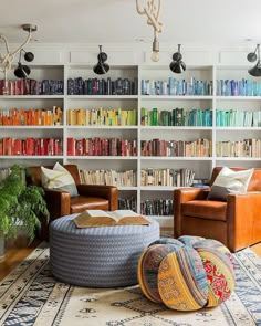 a living room filled with lots of furniture and bookshelves covered in colorful books