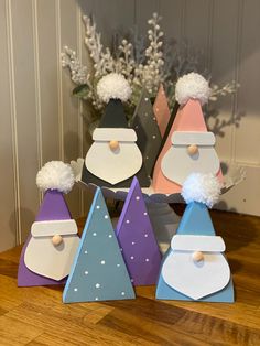 colorful wooden christmas trees with pom - poms on them sitting on a table