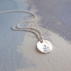 Our delicate Silver Hammered Disc Necklace is 925 Sterling Silver. The tiny silver disc has been gently hammered giving it an interesting texture that reflects the light beautifully. The disc pendant has been hand stamped with a tiny leaf print - a perfect gift for a nature lover! Details: * Necklace length 18'' * The fine curb chain is sterling silver * The tiny disc pendant measures approx. 9mm Your silver disc necklace will arrive carefully packaged and presented in a Silver Willow gift box, making it a perfect gift for a loved one or a special treat for yourself. Matching Silver Disc Earrings available: https://www.etsy.com/uk/listing/1250063904/hammered-silver-earrings See more Jewellery from SilverWillowUK: https://www.etsy.com/uk/shop/SilverWillowUK Thank you for looking!