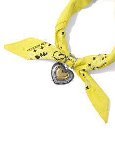 a yellow scarf with a heart charm on it