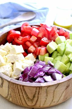 a wooden bowl filled with different types of vegetables