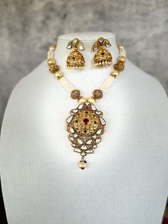 Multi pearl strand with gold beads attached with bikaneri kundan pendant and traditional jhumki's to complete the look. Perfect for any occasion parties, wedding or festivities. 22k Gold Pearl Necklace For Celebrations And Festivals, Gold Kundan Necklace With Cutdana For Eid, White 22k Gold Kundan Necklace With Intricate Design, Traditional Kundan Gold Pearl Necklace, Traditional Gold Kundan Pearl Necklace, Diwali White Kundan Necklace In 22k Gold, Traditional Kundan Necklace With Latkans For Eid, White 22k Gold Kundan Necklace For Diwali, Gold Bollywood Pearl Necklace For Festive Occasions