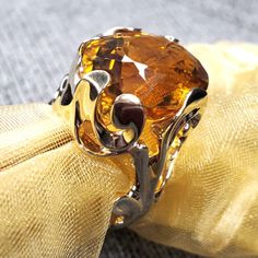 * This 14K yellow gold ring is glorious in its uniqueness. Its yellow gold filigree setting surrounds an oval cut citrine. The gold "lace" surrounding the center stone embellishes the orange sparkling citrine perfectly. This unique piece will draw attention no matter what the occasion.  * This would make a perfect gift for a trusted friend or loved one or as a perfect November birthstone. *  This ring weighs 14.0 grams, measures at 21.5 mm at its widest point, the shank tapers to 3 mm and stands at 11.7 mm off of the hand. It is stamped "585" inside the shank, which is European stamp for "14K", and is a US size US 7 1/4 Please message us about sizing options prior to purchase! * This ring is a vintage item, and like all vintage pieces may have some slight wear. However, this ring is in won Yellow Gold Cocktail Ring, Gold Cocktail Ring, Gold Cocktail, Citrine Stone, Gold Lace, November Birthstone, Gold Filigree, Yellow Gold Ring, Vintage Pieces