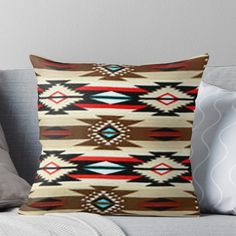 a throw pillow with an abstract design on the front and back of it, sitting on a couch