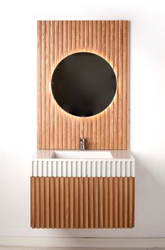 a bathroom sink with a mirror above it and wooden paneling on the wall behind it