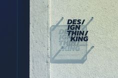 a white wall with the words desi ign thin / king on it