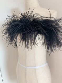 a white mannequin with black feathers on it