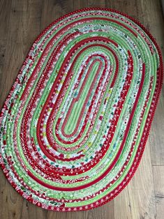 a red and green rag rug on a wooden floor