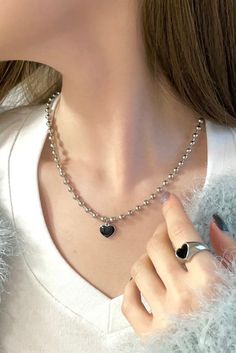 Get ready to rock the glam punk vibes with our Heartbreaker Necklace. This statement piece features a thick 4mm ball chain that exudes edgy style. The centerpiece is a heart charm, painted in monochrome for a bold and eye-catching look. The combination of the chunky chain and the punk-inspired heart charm creates a perfect blend of retro and contemporary aesthetics. - Chain: approx. 17", Nickel-free Alloy- Charm: approx. 12mm (0.47"), Nickel-free Alloy, Epoxy Trendy Metal Heart Beads Necklace, Trendy Metal Heart Necklace With Heart Beads, Trendy Metal Heart Necklace, Trendy Metal Heart Necklace For Everyday, Trendy Everyday Metal Heart Necklace, Punk Black Necklace With Heart Pendant, Punk Black Heart Pendant Necklace, Black Punk Heart Pendant Necklace, Punk Style Black Heart Pendant Necklace