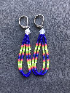 Handmade earrings. Native American beaded earrings made with size 11 seed beads Colors are super bright matte neons pink, orange, green, yellow, white and blue made with a clear matte AB bicone bead topper They measure about 2 inches long with a stainless steel leverback hooks. I now offer free shipping on orders $35.00 and over! Handmade Neon Jewelry For The Beach, Beaded Tutorials, Earrings Native American, Beads Colors, Native American Beaded Earrings, Native Beadwork, American Indian Jewelry, Jewelry Making Project, Loop Earrings