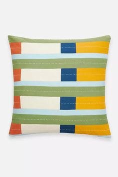 a multicolored striped pillow on a white background with blue, green, yellow and orange stripes