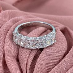 a diamond ring sitting on top of a pink cloth