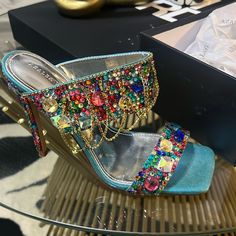 Shine On In The Azalea Wang Envie Multi Gemstone Jewel Drape Sandal. This Statement-Making Shoe Features A Glittery Textile Upper, An Open Square Toe Silhouette, Gem-Embellished Toe And Foot Bands, Rhinestone Link Draped Detailing, Faux Gold Hardware, A Cushioned Silver Metallic Faux Leather Insole, And A Slip-On Fit. Complete With A Slim, Gemstone-Adorned Stiletto Heel. Pair This Sparkling Style With All Black And Your Fave Statement Accessories For A Complete Look. (All Measurements Approximat Luxury Bedazzled Sandals For Party, Multicolor High Heel Sandals With Rhinestones, Multicolor Rhinestone High Heel Sandals, Luxury Multicolor Sandals For Party, Luxury Multicolor Party Sandals, Luxury Silver Sandals With Rhinestones, Designer Embellished Silver Sandals, Designer Multicolor Sandals For Party, Multicolor Crystal Embellished Party Heels