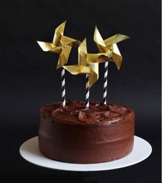 a chocolate cake topped with two gold birds on top of it's icing