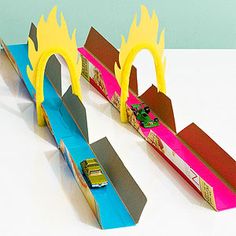 a toy car is driving on a track made out of construction paper and cardboard with flames coming out of it