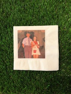 a man and woman standing on top of a lush green grass covered field next to each other