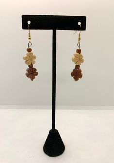 Handcrafted wooden flower shaped earrings are beige and brown with 2 small wooden beads in between. These earrings measure 2 1/2" from top of earwire to bottom and have a 1 1/2" dangle. Brown Dangle Flower Earrings, Brown Flower Drop Earrings, Brown Dangle Flower Earrings For Pierced Ears, Handmade Beige Flower-shaped Earrings, Brown Flower Earrings With Ear Wire, Beige Flower-shaped Earrings For Gift, Beige Flower Earrings For Gift, Vintage Brown Flower Earrings, Brown Flower Earrings