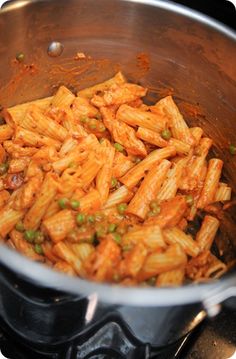 a pot filled with pasta and peas on top of a stove