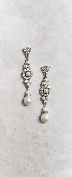 two pairs of pearl and crystal earrings on a white background with space for text or image