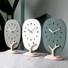 three clocks with different designs on them sitting on a table