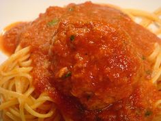 spaghetti and meatballs on a white plate