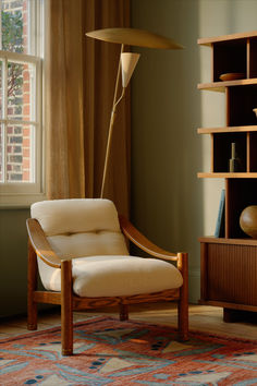 a living room with a chair, lamp and bookshelf