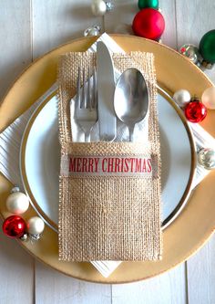 a place setting with silverware and christmas decorations