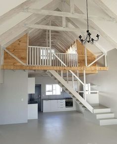 an empty loft with stairs leading up to the second floor