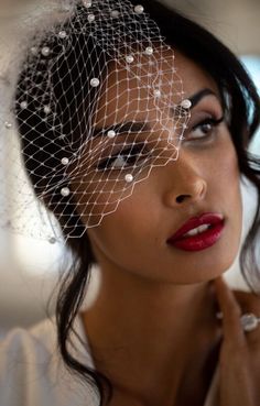 a woman wearing a veil with pearls on it