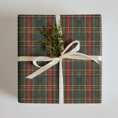 a present wrapped in plaid paper with a white ribbon