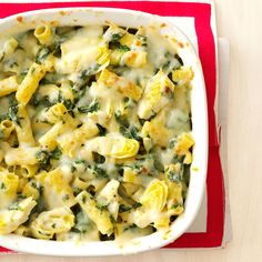 a casserole dish filled with pasta and spinach