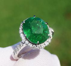 A Breathtakingly Striking HANDMADE 14k White Gold Ring with Beautiful Oval Cut Tsavorite in Green color! The GEM is 7.20CT and measures 12.00x9.93x7.04 mm! This Stone will take your breath away, especially on the sunlight! You will want to look at this stone endlessly. The mounting is a masterpiece! HANDMADE 14K White Gold Diamond Mounting (tested), that was is custom made to Accommodate this Beauty of a Gem in a V-prongs setting! Super FINE Workmanship on the Diamond v-split setting with 32 pcs Brilliant Full Cut Diamonds in GH color, SI1 clarity, totaling to approx  0.53 ct! Fabulous Braided Band and Diamond Gallery! The Entire Top's outline is 14.6x13.3 mm- HUGE. The Ring weights 5.6g, nice and SOLID. Sits 6.9 mm off the top of the finger. Finger size 7 (Free Re-sizing with purchase). C Luxury Gia Certified Emerald Gemstones, Exquisite Oval Brilliant Cut Gemstones, Exquisite Oval Brilliant-cut Gemstones, Luxury Oval Emerald Gemstones, Elegant Oval Gia Certified Gemstones, Luxury Green Oval Gemstones, Gia Certified Oval Gemstones For Fine Jewelry, Luxury Brilliant Cut Green Gemstones, Luxury Green Gemstones With Halo Setting