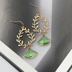 These are beautiful and elegant laurel wreath earrings with green teardrop glass crystals. The laurel wreath pendants are 14K gold plated and have beautiful details on both front and back.  Earrings are lightweight and very comfortable to wear. Measurements: The total length from the top of the hook to bottom - 2.16 inches (55 mm) approximately. Laurel wreath: 25 mm x 30 mm Crystal: 19 mm x 16 mm These earrings would be a PERFECT GIFT for you and your family and friends! Come beautifully package Elegant Green Leaf-shaped Jewelry, Green Botanical Drop Earrings, Green Leaf-shaped Earrings As A Gift, Green Leaf-shaped Earrings For Pierced Ears, Elegant Green Leaf-shaped Earrings, Gold Laurel Wreath, Green Leaf-shaped Earrings, Wreath Earrings, Statement Earrings Gold