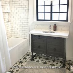 a white bathroom with black and white tile on the floor, sink and bathtub