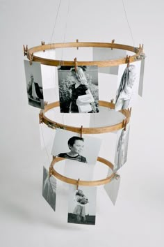 several pictures hanging from a wooden frame with clothes pins attached to them and photos on the strings