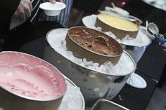 there are many different types of cakes on the table and in buckets with ice cream