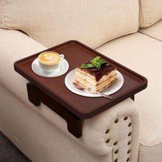 a piece of cake sitting on top of a wooden tray next to a cup of coffee