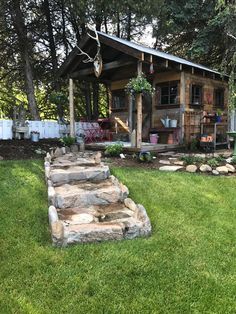 a small wooden cabin with steps leading to the front door and patio area in the back yard