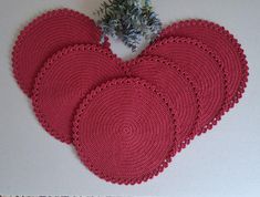 four crocheted placemats in the shape of hearts