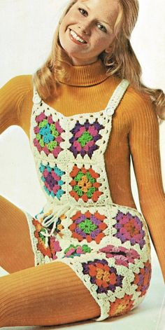 a woman sitting on the ground wearing a colorful crochet dress