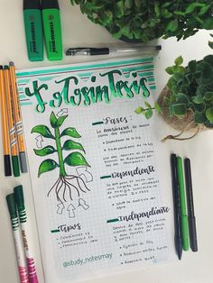 a clipboard with some plants and pens on it