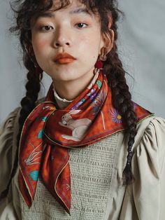 a woman with braids wearing an orange scarf