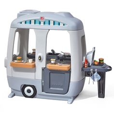 a toy kitchen with an oven and table in front of it on a white background