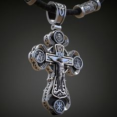 a silver cross on a black leather cord