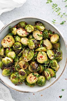 a white bowl filled with brussel sprouts on top of a table