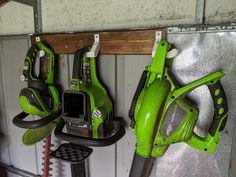 some green tools are hanging on the wall